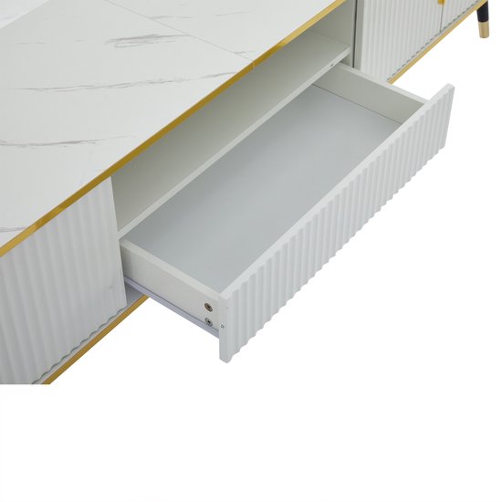 Detail van een open lade in een witte tv-kast met ribbelpatroon en gouden rand.