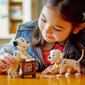 Een meisje bouwt met LEGO Disney Dalmatiërs, waaronder Lucky en Penny bij een televisie.