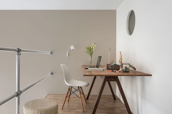 Bureau met houten tafel, witte stoel, laptop en decoraties.