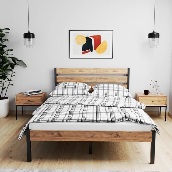 Houten bedframe met zwart metalen frame, wit/zwart geruite deken en kussens, in slaapkamer.
