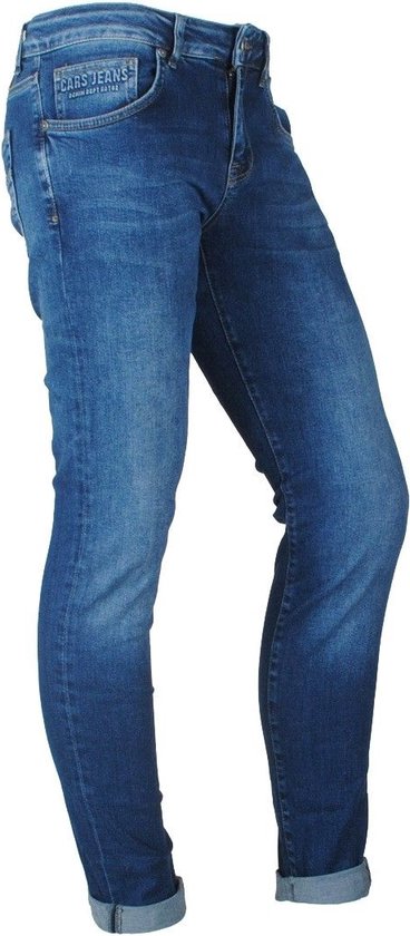 Model in een blauwe skinny jeans met stone washed effect, op een witte achtergrond.