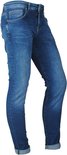 Model in een blauwe skinny jeans met stone washed effect, op een witte achtergrond.