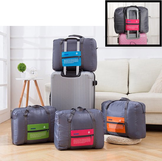 Opstelling met tassen: twee grijze tassen met kleurvakken (groen, roze, oranje), en een grijze tas met blauw vak op een koffer. Detail van tas op koffer.