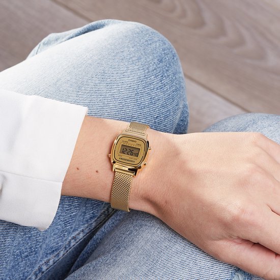 Gouden Casio dameshorloge met mesh band, gedragen aan een pols met sproeten.
