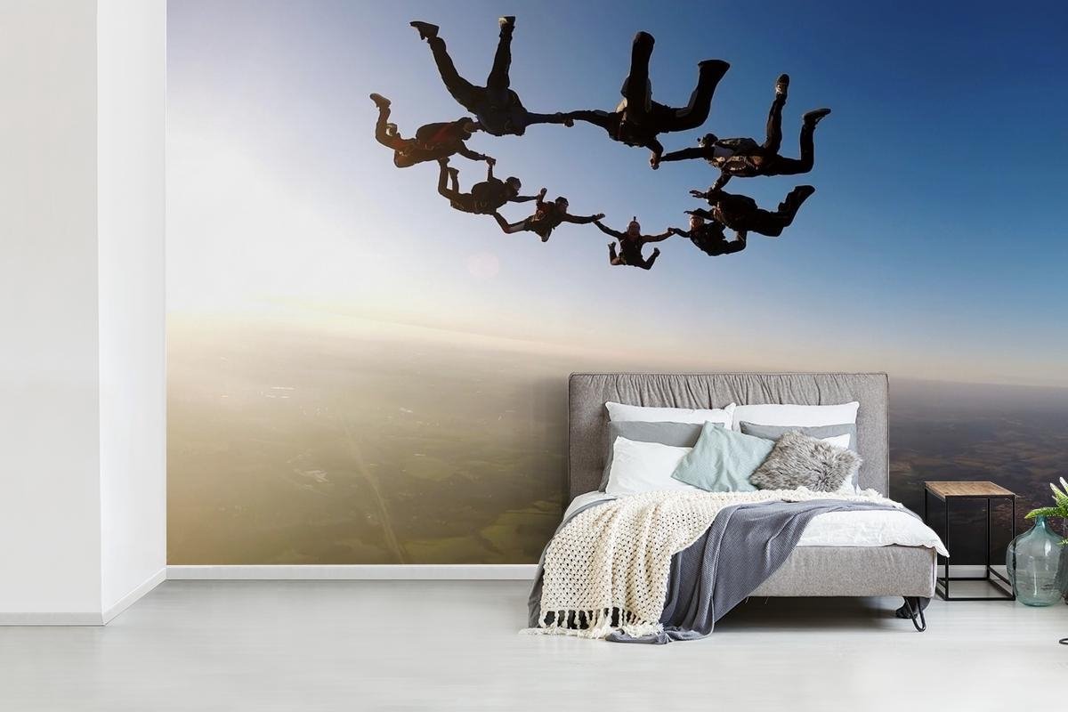 Fotobehang Sky Dive - Skydiven in zonsonrgang breedte 625 cm x hoogte 400 cm - Foto print op vinyl behang (in 7 formaten beschikbaar) - slaapkamer/woonkamer/kantoor - Nr1Wallpaper