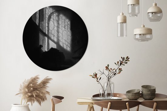 Un homme lisant dans une chambre haute - Peinture de Rembrandt van Rijn Plaque en plastique de cercle mural