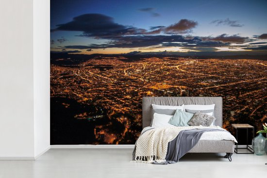 Behang - Fotobehang Een kleurrijke zonsopkomst boven Bogota in Colombia - Breedte 600 cm x hoogte 400 cm