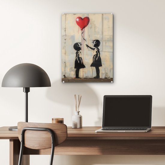 Twee silhouetten van meisjes op een muur met verfspatten, één meisje laat een rood hartvormige ballon los.