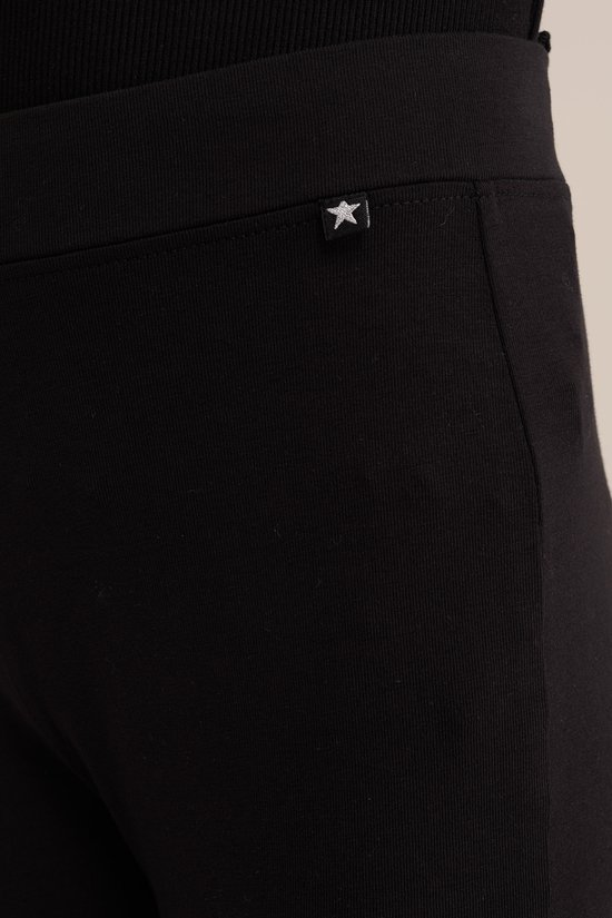 Zwarte flared legging met een kleine witte ster op de tailleband.