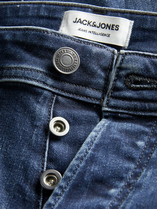Close-up van de knoopsluiting van een blauwe jeans, met 'JACK&JONES JEANS INTELLIGENCE' label.
