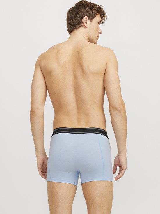 Man van achteren gezien, draagt lichtblauwe boxershorts met een zwarte tailleband.