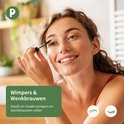 Vrolijke vrouw met een groene tanktop brengt mascara aan op haar wimpers. Tekst: 'Wimpers & Wenkbrauwen, Voedt en maakt wimpers en wenkbrauwen voller'.