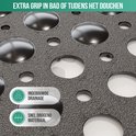Close-up van een zwarte antislipmat met ingebouwde drainage en snel drogend materiaal.