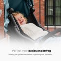Een lachend jong kind in een lichtgroene buggy, perfect voor dutjes onderweg met 3 verstelbare rugleuningposities.