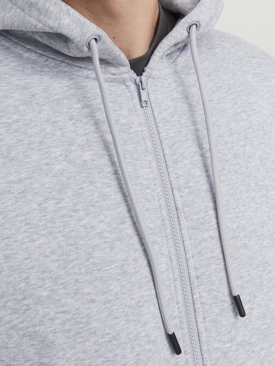 Close-up van de ritssluiting en de capuchon van een lichtgrijze hoodie.
