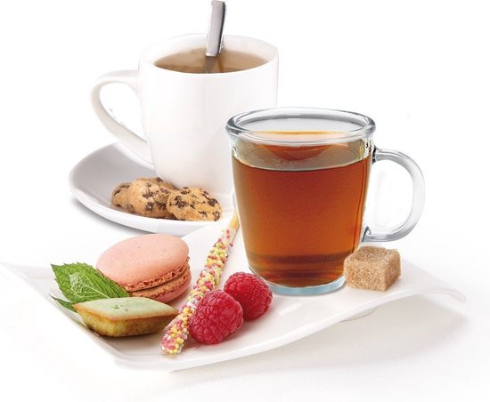 Kopje thee met macarons, frambozen en een koekje op een schaal.