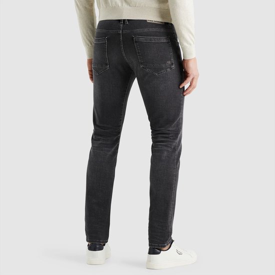 Achterkant man met grijze jeans en witte sneakers