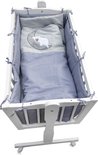 Witte wieg met blauw-wit geblokte bekleding en een dekbed met een maan en schaap motief.