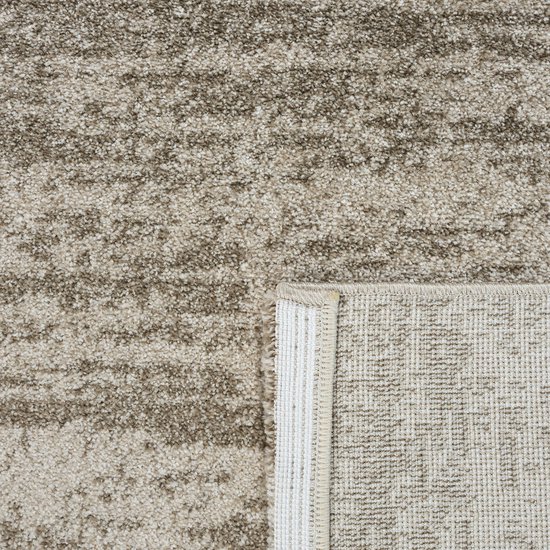 Tapis beige avec un motif abstrait, le dos est visible.