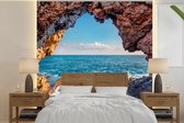 Behang - Fotobehang Grot - Zee - Rotsen - Natuur - Breedte 240 cm x hoogte 240 cm