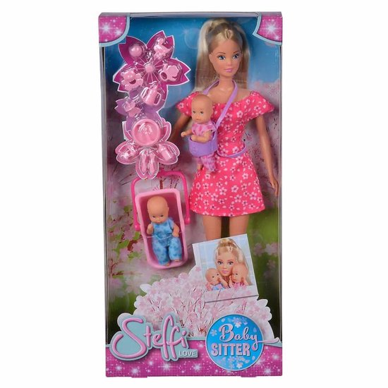 Doos met Steffi Love pop als babysitter. Ze draagt een roze jurk en een babydrager met baby. Een wiegje met baby staat naast haar.