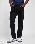 Man in donkerblauwe top en zwarte jeans, met witte sneakers met strepen.