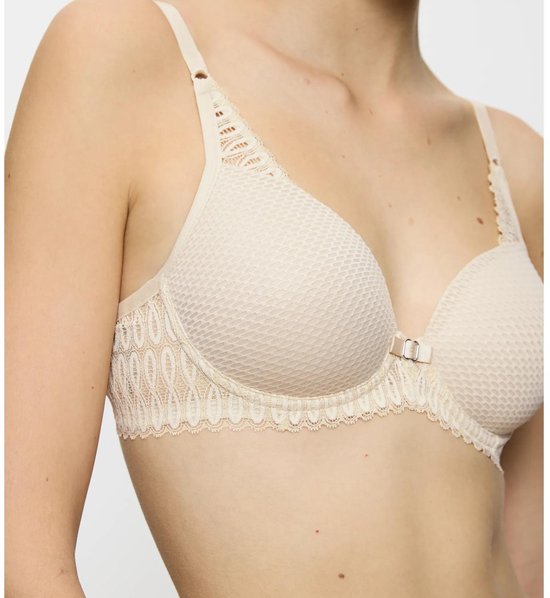 Gros plan sur un soutien-gorge à armatures beige à motif hexagonal et détails en dentelle.