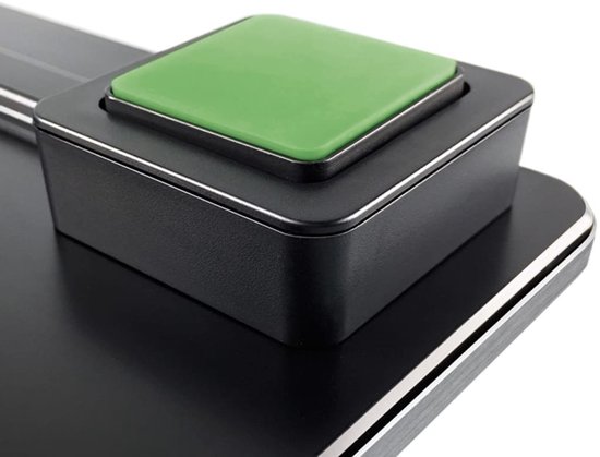 Close-up van een vierkante groene knop op een zwarte, metalen weegschaal.