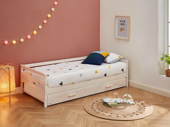 Wit houten dagbed met onderschuifbed, speelgoed en decoratie.