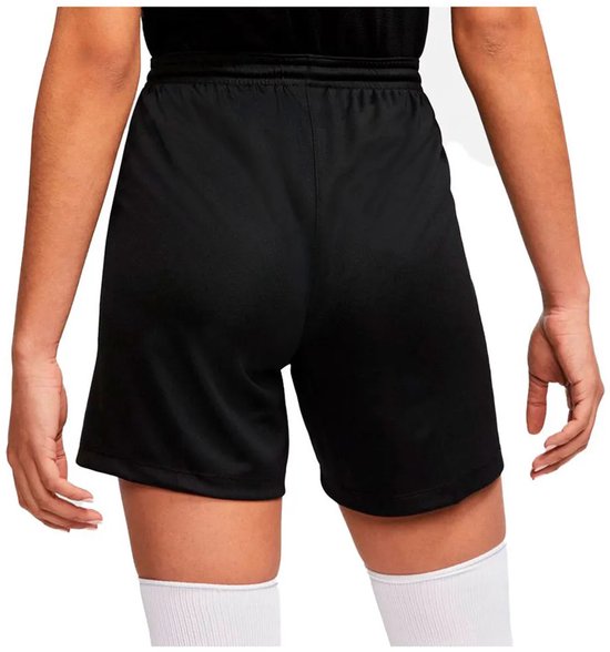 Achterkant van zwarte Nike voetbalbroek met wit Nike logo. Model draagt witte sportsokken.