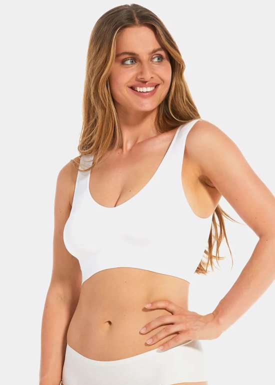 Model draagt een witte, mouwloze, beugelloze BH met een diepe V-hals.