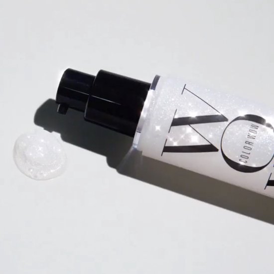 Fles met zilverkleurige glitters, met een pompje en een druppel product ernaast.
