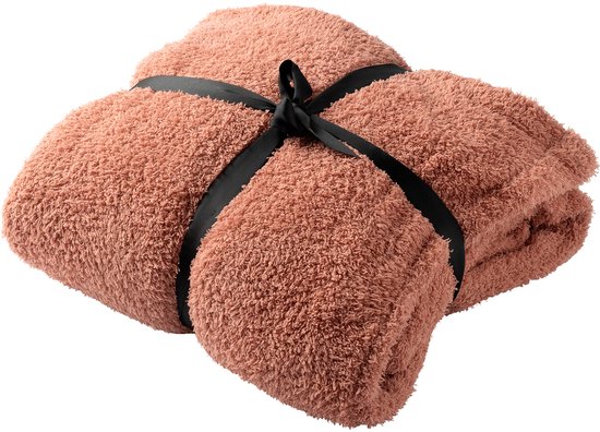 Een roze teddy hoodie deken, opgevouwen en vastgebonden met een zwart lint.