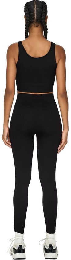Zicht op de achterkant van een model met zwarte crop top en zwarte, nauwsluitende sportlegging met hoge taille en geribd patroon.
