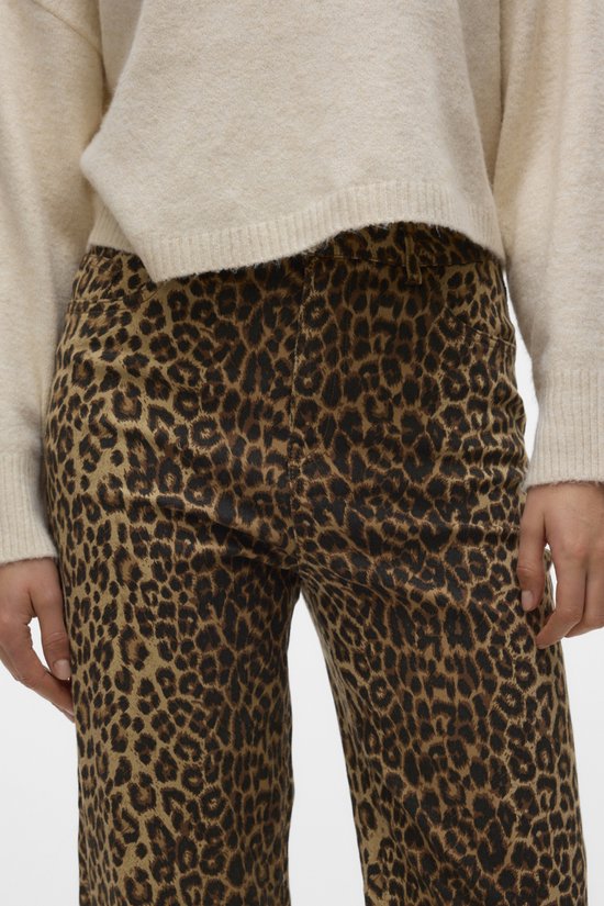 Model in wijde jeans met luipaardprint en gebroken wit trui.