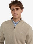 Man met beige trui met 'MCG' logo en ritssluiting.