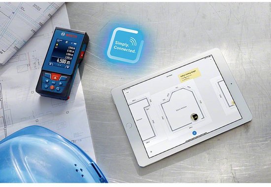 Bosch laser afstandsmeter naast een tablet waarop een plattegrond staat, met bouwplannen en helm.