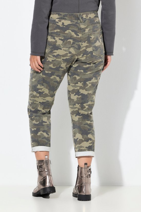 Achteraanzicht van een camouflage cargobroek met omgeslagen zoom, gedragen met metallic laarsjes.
