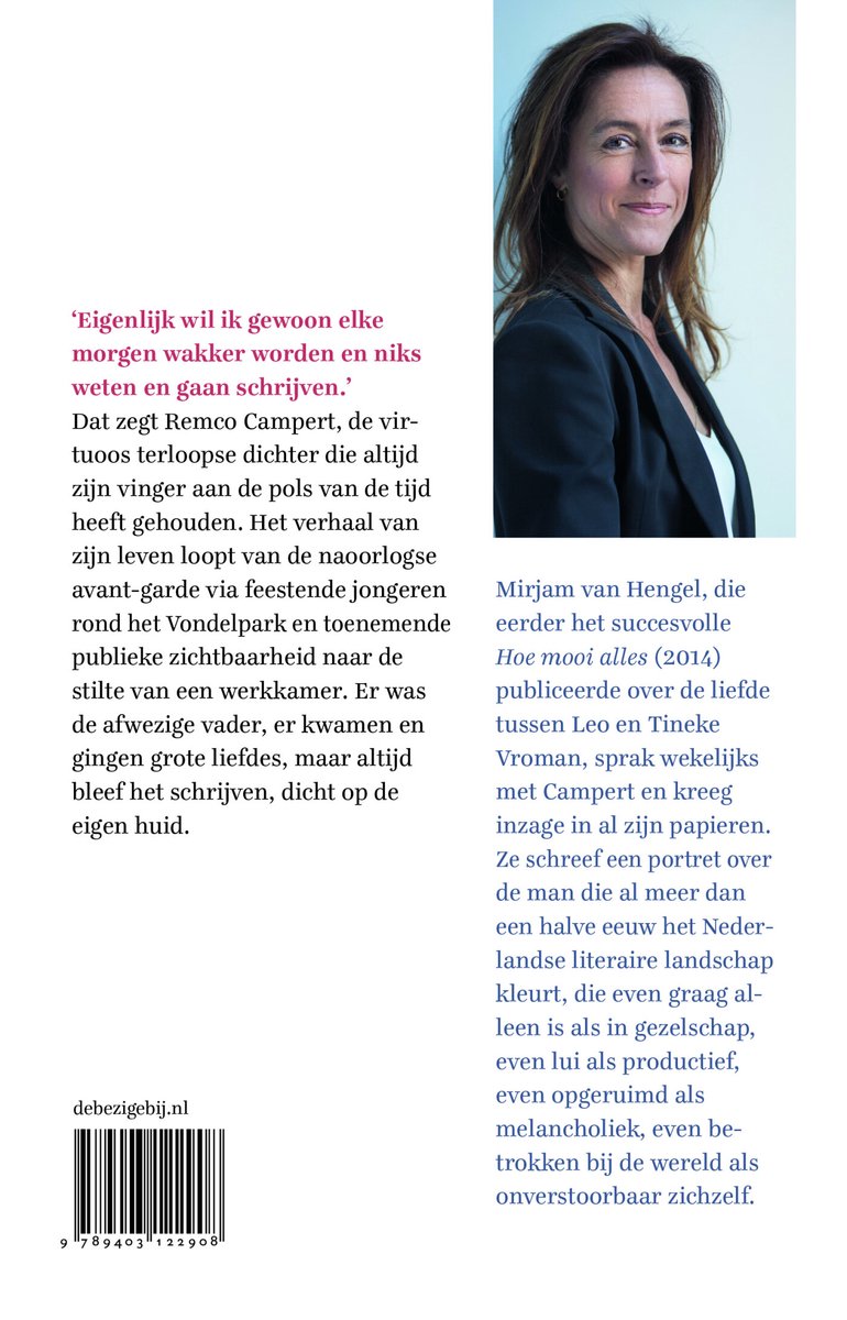 Vrouw in donkere blazer met witte blouse, lachend naar de camera. Achtergrond van een boek.