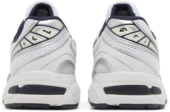 Achterkant van witte sneakers met zilveren details en donkerblauwe kraag.