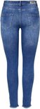 Achterkant van een vrouw in een blauwe skinny jeans met rafelige zoom, gedragen met zwarte pumps.