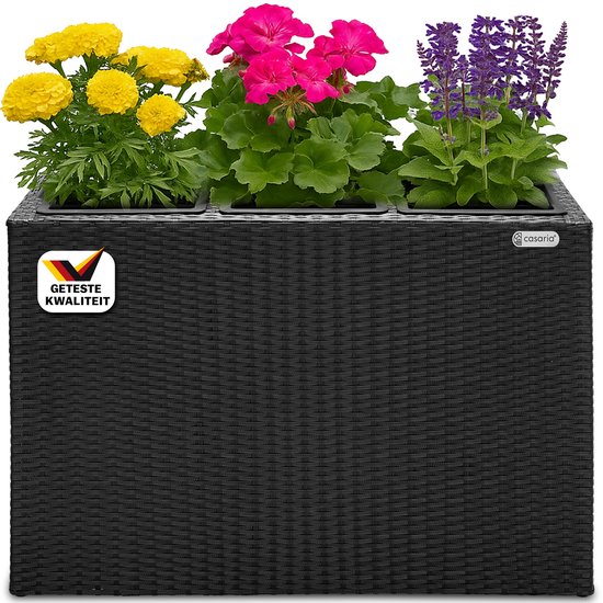 Zwarte plantenbak in polyrotan-look met drie vakken en gele, roze en paarse bloemen. Met "Geteste Kwaliteit" sticker.