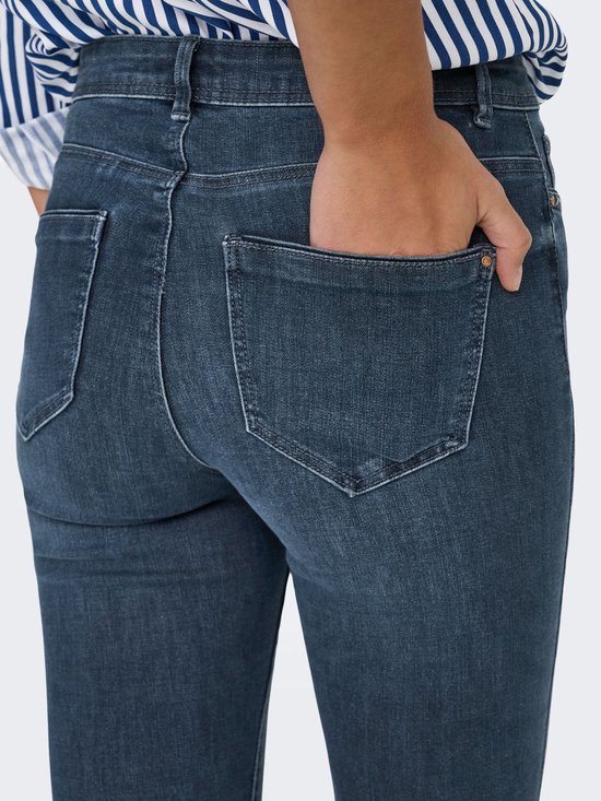 Donkerblauwe skinny jeans met een hoge taille, close-up van de achterzakken.