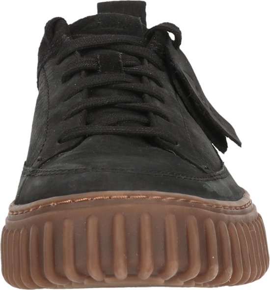 Voorkant van zwarte sneaker met bruine plateauzool.