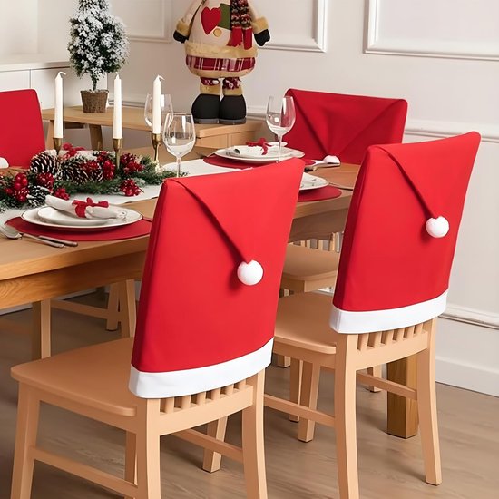 Close-up van houten stoelen met rode kerstmuts hoezen, voorzien van witte pluche pompons.