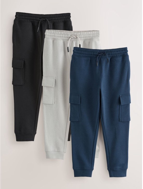 Drie cargobroeken in zwart, grijs en blauw, met trekkoord en cargozakken.
