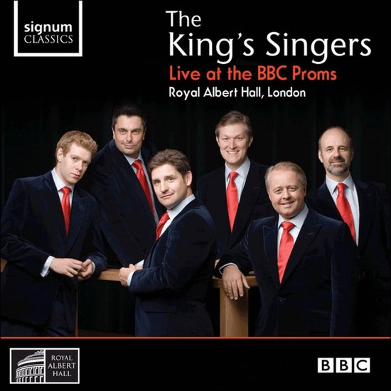 Promotionele foto van The King's Singers, zes mannen in pakken met rode stropdassen, voor een houten reling.