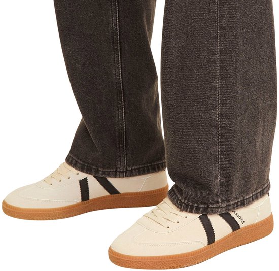 Beige suède sneakers met zwarte strepen en gummen zool.