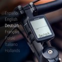 Zwarte Sigma fietscomputer op fietsstuur. Het scherm toont 'Deutsch'. De talenlijst links toont 'Deutsch'.