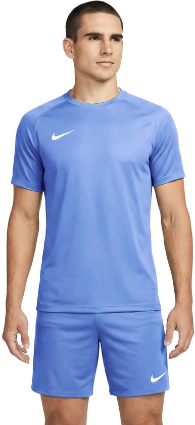 Man in lichtblauw Nike sportshirt met korte mouwen en witte swoosh. Draagt bijpassende korte broek.